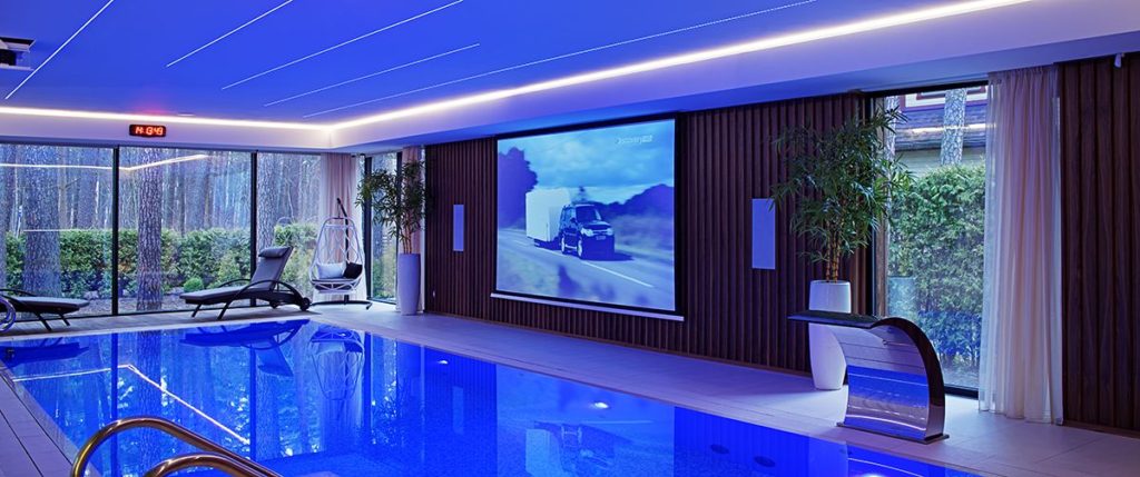 overdekt zwembad met bioscoopscherm in een helderblauwe sfeer