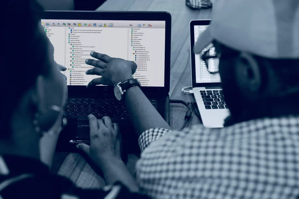 two people in front of a laptop displaying GoldenGate software